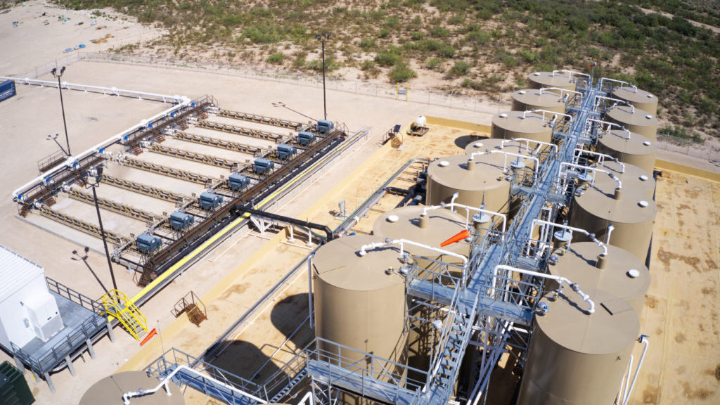 Upstream oil and gas production facility with storage tanks and equipment