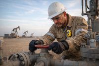 Oil field worker reviewing operational data on a tablet in the field